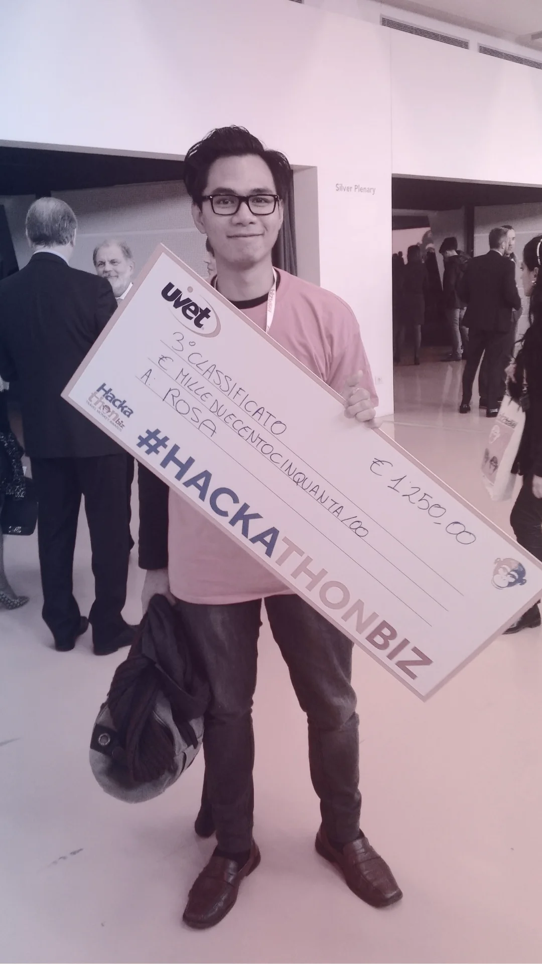 Rey holding a hackathon prize cheque